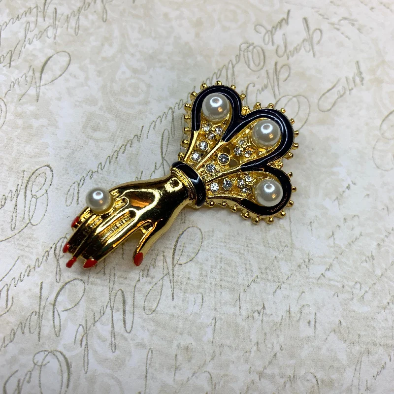 Hand with pearls brooch