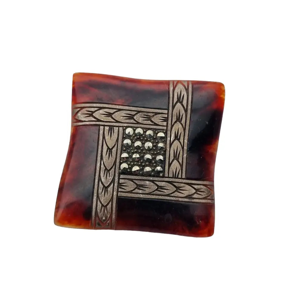 Retro celluloid brooch from the 50s, in brown tone with rhinestones and carved border.