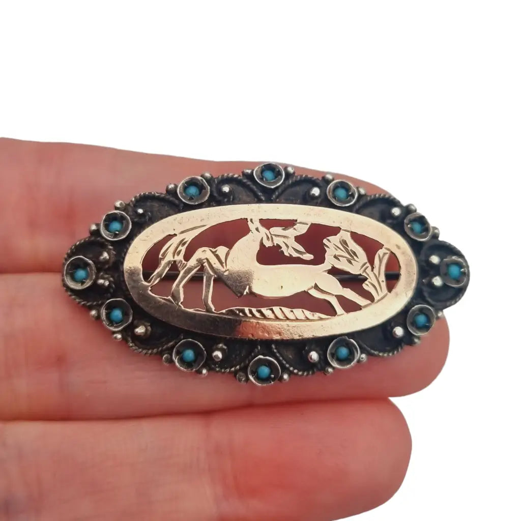 Vintage deer brooch in openwork 925 silver and oval frame with blue rhinestones.